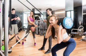 Group participating in circuit training with various gym equipment.