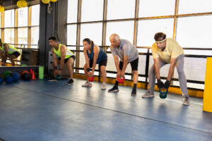 Group of people performing kettlebell exercises during a CrossFit class.