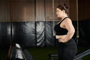 Woman in athletic wear standing in a gym, looking focused and determined