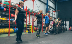 Group of athletes performing jump rope and air bike exercises during a circuit training session